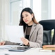 Businesswoman or female office worker is reading a document while sitting at working desk in office. Businesswoman or female office worker is reading a document while sitting at working desk in office. - PhotoDune Item for Sale
