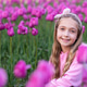 Adorable little caucasian blonde girl smiling in tulip field at spring day Adorable little caucasian blonde girl smiling in tulip field at spring day - PhotoDune Item for Sale