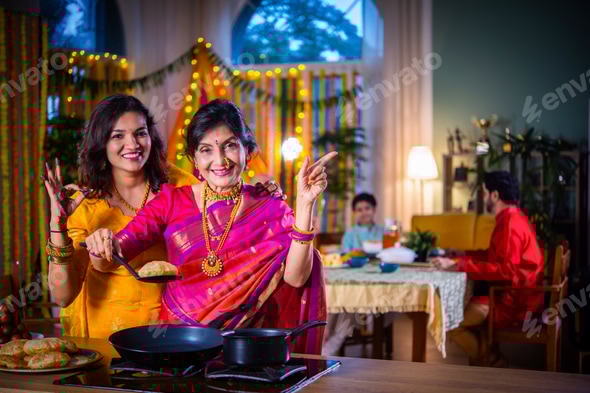 Indian old woman and young daughter in traditional cloths cooking