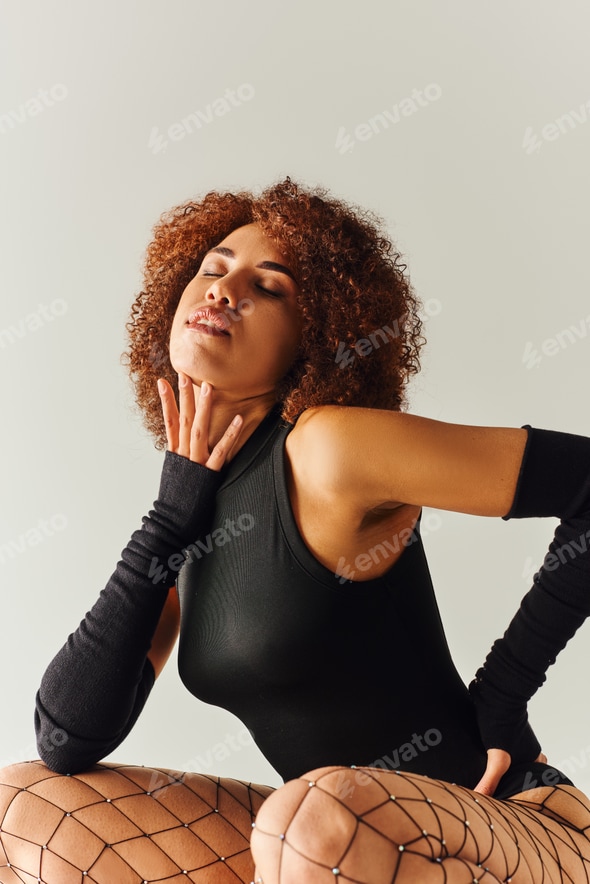 appealing african american woman in fishnet tights and sexy bodysuit posing alluringly, fashion Stock Photo by LightFieldStudios appealing african american woman in fishnet tights and sexy bodysuit posing alluringly, fashion Stock Photo by LightFieldStudios