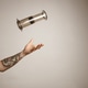 Tattoed man's arm throwing and catching aeropress Tattoed man's arm throwing and catching aeropress - PhotoDune Item for Sale