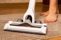 Close up of vacuum cleaner on the carpet with woman legs behind Close up of vacuum cleaner on the carpet with woman legs behind - PhotoDune Item for Sale