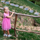Young girl in a pink dress standing by a wooden fence in a park Young girl in a pink dress standing by a wooden fence in a park - PhotoDune Item for Sale