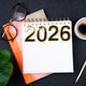 New year goals 2026 on desk. 2026 resolutions list with notebook, plant on black table New year goals 2026 on desk. 2026 resolutions list with notebook, plant on black table - PhotoDune Item for Sale