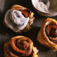 Baked cinnamon bun rolls with white vanilla bean cream frosting. Moody food photo.Closeup flat lay Baked cinnamon bun rolls with white vanilla bean cream frosting. Moody food photo.Closeup flat lay - PhotoDune Item for Sale