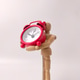 Small, red, retro-style analog alarm clock held by a wooden articulated mannequin Small, red, retro-style analog alarm clock held by a wooden articulated mannequin - PhotoDune Item for Sale