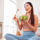 Healthy life concept with Asian woman in fitness on yoga mat and eating vegetable salad at home Healthy life concept with Asian woman in fitness on yoga mat and eating vegetable salad at home - PhotoDune Item for Sale