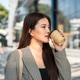 Pretty asian woman carrying bag drinking coffee while standing or walking outside a mall's building. Pretty asian woman carrying bag drinking coffee while standing or walking outside a mall's building. - PhotoDune Item for Sale