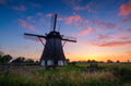 Windmills in the Netherlands. Historic buildings. Agriculture. Summer landscape during sunset. Windmills in the Netherlands. Historic buildings. Agriculture. Summer landscape during sunset. - PhotoDune Item for Sale