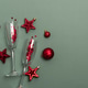 Champagne Flutes and Red Christmas Decorations on Green Background Champagne Flutes and Red Christmas Decorations on Green Background - PhotoDune Item for Sale