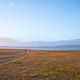 Car driving on dirt road through dry grassy steppe near lake and mountains Car driving on dirt road through dry grassy steppe near lake and mountains - PhotoDune Item for Sale