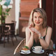 Portrait of young smiling woman with blonde hair in street bistro Portrait of young smiling woman with blonde hair in street bistro - PhotoDune Item for Sale