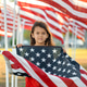 Patriotic holiday girl holding an American flag on a Memorial Day and looking at camera Patriotic holiday girl holding an American flag on a Memorial Day and looking at camera - PhotoDune Item for Sale