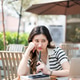 Worried asian woman resting head on hand looking at laptop as sitting at wooden table in garden cafe Worried asian woman resting head on hand looking at laptop as sitting at wooden table in garden cafe - PhotoDune Item for Sale