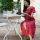 young African American woman in burgundy dress looks at menu and orders tea in coffee shop in park young African American woman in burgundy dress looks at menu and orders tea in coffee shop in park - PhotoDune Item for Sale