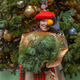 A woman in a red clothes with a bouquet of fir branches walks along the Christmas decorated streets A woman in a red clothes with a bouquet of fir branches walks along the Christmas decorated streets - PhotoDune Item for Sale