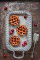 Flat lay of three individual cherry pies and fresh cherries on a serving tray on rustic background Flat lay of three individual cherry pies and fresh cherries on a serving tray on rustic background - PhotoDune Item for Sale