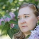 A blonde woman stands near blooming lilacs in a city park. Summer. A blonde woman stands near blooming lilacs in a city park. Summer. - PhotoDune Item for Sale