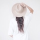 Brunette girl in a beige hat and white shirt against a light wall Brunette girl in a beige hat and white shirt against a light wall - PhotoDune Item for Sale