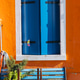 Burano island colorful house with blue window shutters Burano island colorful house with blue window shutters - PhotoDune Item for Sale