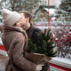 Happy couple in cozy winter outfits with spruce bouquet at festive Christmas market. Romance Happy couple in cozy winter outfits with spruce bouquet at festive Christmas market. Romance - PhotoDune Item for Sale