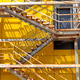 unique metal staircase with vibrant yellow background showcasing shadows in industrial setting. unique metal staircase with vibrant yellow background showcasing shadows in industrial setting. - PhotoDune Item for Sale