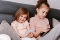 Two little girls sisters sitting in bedroom, holding gadgets. Kids using technologies at home Two little girls sisters sitting in bedroom, holding gadgets. Kids using technologies at home - PhotoDune Item for Sale