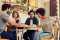 Cheerful young friends having fun in a cafe Cheerful young friends having fun in a cafe - PhotoDune Item for Sale