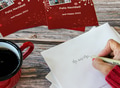 Woman addressing Christmas cards envelopes to be sent to friends & family as Christmas tradition. Woman addressing Christmas cards envelopes to be sent to friends & family as Christmas tradition. - PhotoDune Item for Sale