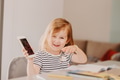 Cute toddler little girl holding smartphone, sitting at table at kitchen, kids using technology Cute toddler little girl holding smartphone, sitting at table at kitchen, kids using technology - PhotoDune Item for Sale