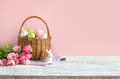 Wicker basket with easter eggs and pink tulips. Spring easter pink background with space for text. Wicker basket with easter eggs and pink tulips. Spring easter pink background with space for text. - PhotoDune Item for Sale