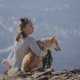 A girl with a pet sitting against the backdrop of winter mountains looking away A girl with a pet sitting against the backdrop of winter mountains looking away - PhotoDune Item for Sale