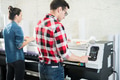 Man and woman using printing equipment Man and woman using printing equipment - PhotoDune Item for Sale