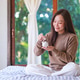 Portrait image of a woman holding and putting coins into piggy bank for saving money concept at home Portrait image of a woman holding and putting coins into piggy bank for saving money concept at home - PhotoDune Item for Sale