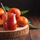Fresh tangerines with green leaves arranged on wooden slab, alongside glass jar of homemade jam Fresh tangerines with green leaves arranged on wooden slab, alongside glass jar of homemade jam - PhotoDune Item for Sale