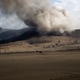 Silhouette of horseback rider riding across volcanic brown sand landscape with smoke at the Silhouette of horseback rider riding across volcanic brown sand landscape with smoke at the - PhotoDune Item for Sale