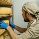 cheese maker in uniform at cheese production man in warehouse with ...