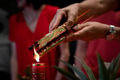 Hand holding joss sticks and candle as prayer and offering to the Gods Hand holding joss sticks and candle as prayer and offering to the Gods - PhotoDune Item for Sale