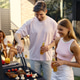 Young couple grilling food at summer backyard barbecue Young couple grilling food at summer backyard barbecue - PhotoDune Item for Sale