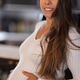 Smiling pregnant woman poses in cozy home setting emphasizing maternity charm Smiling pregnant woman poses in cozy home setting emphasizing maternity charm - PhotoDune Item for Sale