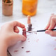 Child's hand painting wooden figurines with a brush on a white sheet of paper Child's hand painting wooden figurines with a brush on a white sheet of paper - PhotoDune Item for Sale