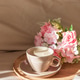 Cappuccino Cup and Flowers on Tray with Satin Bedding in Sunlight. Cappuccino Cup and Flowers on Tray with Satin Bedding in Sunlight. - PhotoDune Item for Sale