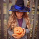 little girl in witch hat with orange pumpkin in her hands near wooden fence at halloween party little girl in witch hat with orange pumpkin in her hands near wooden fence at halloween party - PhotoDune Item for Sale