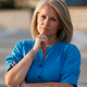 Thoughtful woman in blue shirt with crossed arms outside on a sunny day. Italy Thoughtful woman in blue shirt with crossed arms outside on a sunny day. Italy - PhotoDune Item for Sale