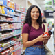 Portrait of smiling woman holding product at supermarket Portrait of smiling woman holding product at supermarket - PhotoDune Item for Sale