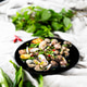 Fresh garlic clams and mussels served on a black plate with vibrant green herbs Fresh garlic clams and mussels served on a black plate with vibrant green herbs - PhotoDune Item for Sale