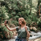 Happy young female traveler with backpack making selfie while standing by the mountain river Happy young female traveler with backpack making selfie while standing by the mountain river - PhotoDune Item for Sale