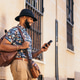 Stylish black man in the city street using smartphone Stylish black man in the city street using smartphone - PhotoDune Item for Sale