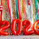Colorful festive decorations with shiny foil backdrop and red balloons in shape of 2026 Colorful festive decorations with shiny foil backdrop and red balloons in shape of 2026 - PhotoDune Item for Sale
