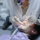 A dentist performs a dental procedure with an ultrasonic scaler on a young patient. A dentist performs a dental procedure with an ultrasonic scaler on a young patient. - PhotoDune Item for Sale